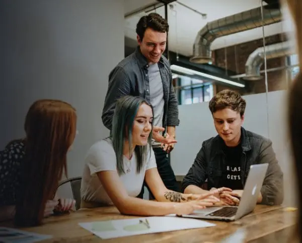 Ponderosa team in planning meeting, 4 team members around a laptop