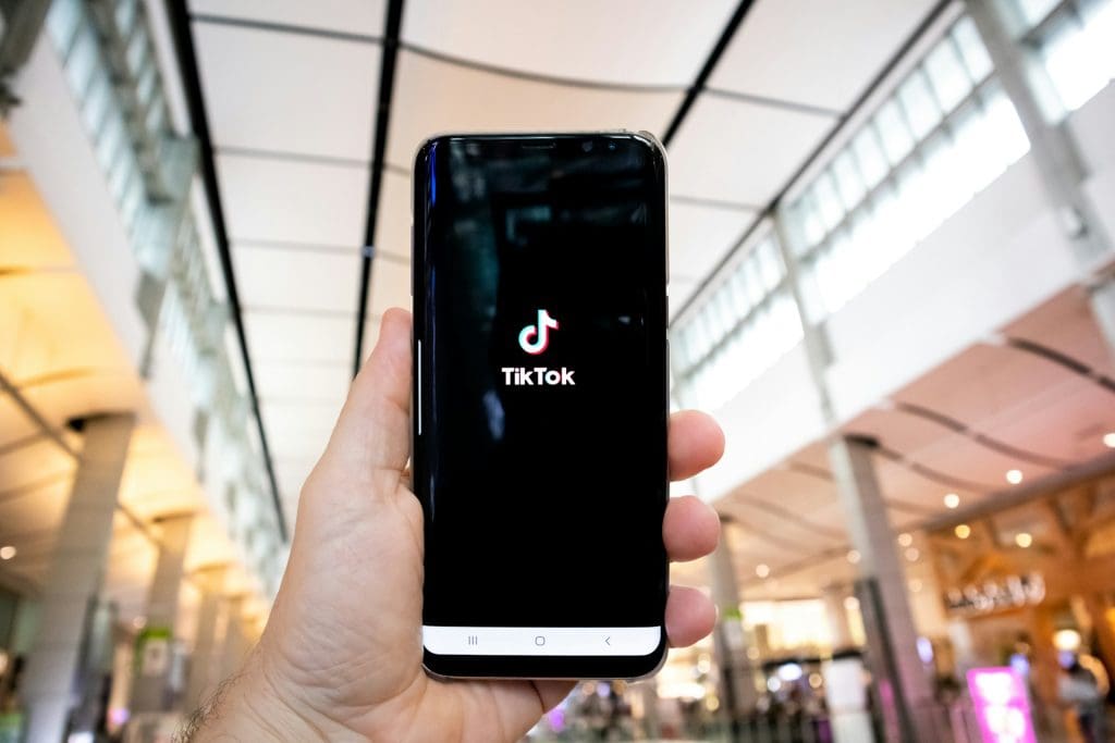 TikTok logo shown on phone in shopping centre